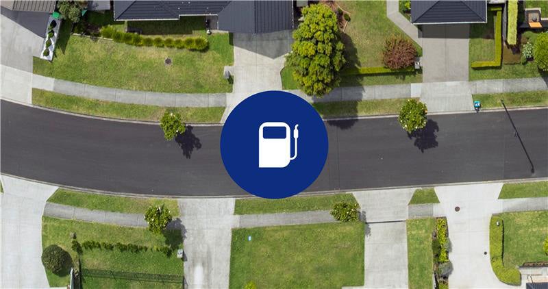 A Subaru Forester Hybrid parked on a snowy mountain road near a group of people gathered around a wheelchair user, with snow-covered cliffs and pine trees in the background under a partly cloudy sky.