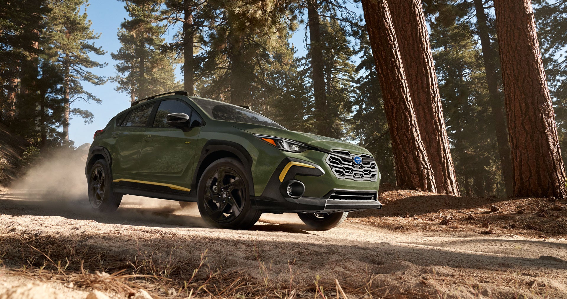 Subaru Crosstrek driving through forest trail.