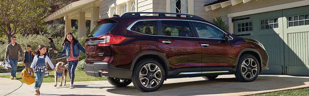 Subaru Ascent SUV parked outside a home with a family walking nearby.