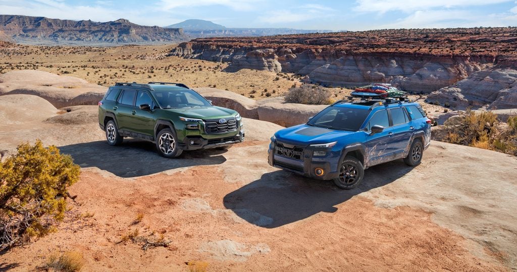 Two Subaru SUVs parked on a desert off-road trail.